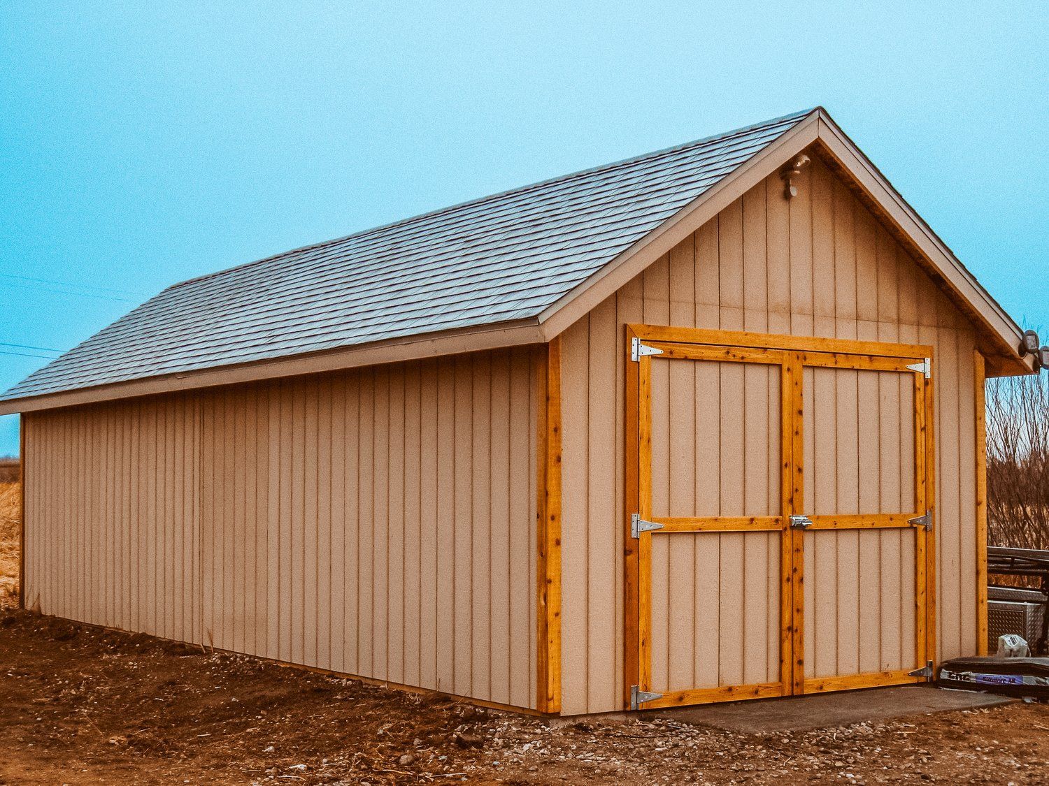 A brown garage with a white roof and wooden doors