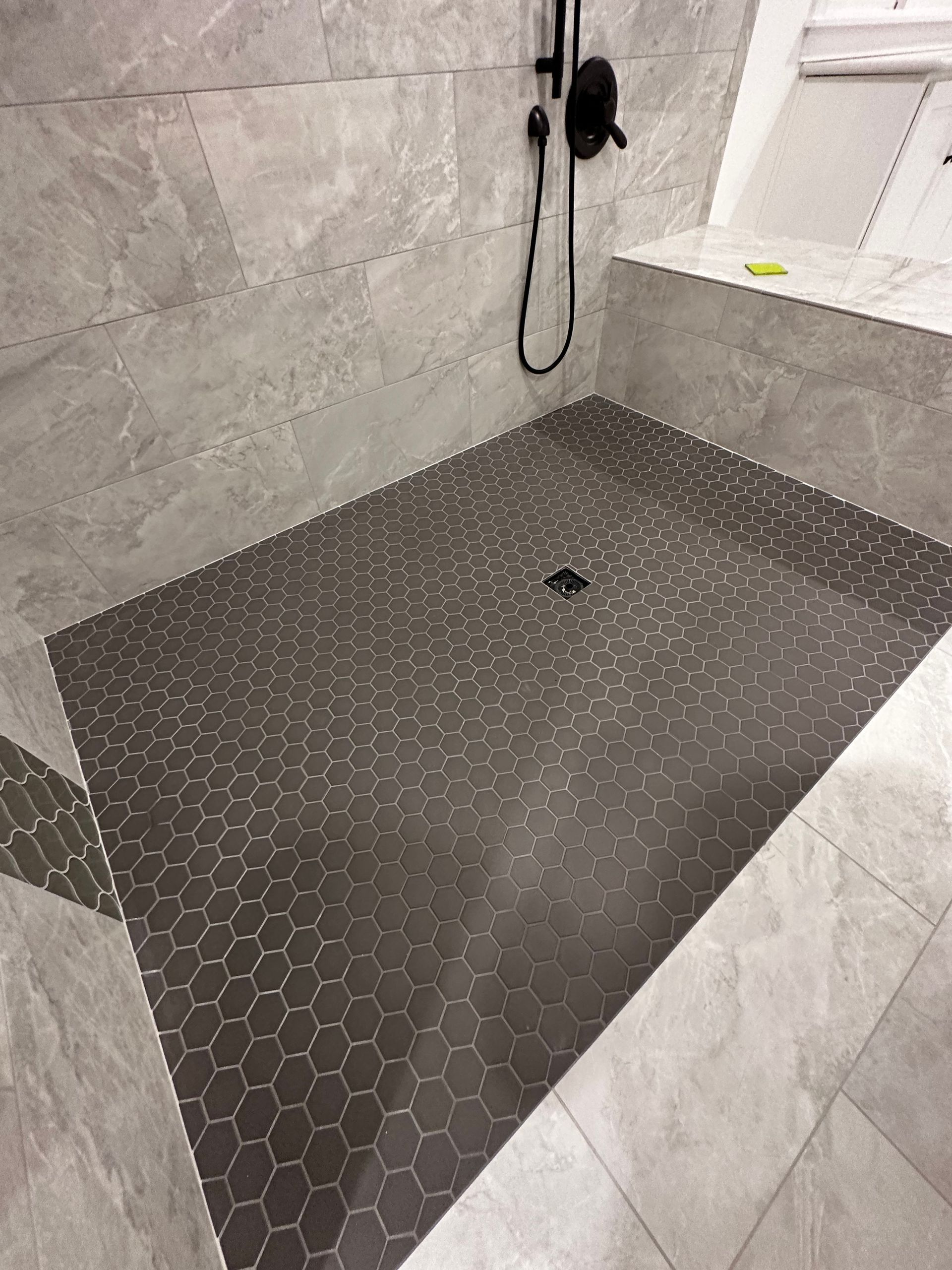 A bathroom with a walk in shower and a shower head.