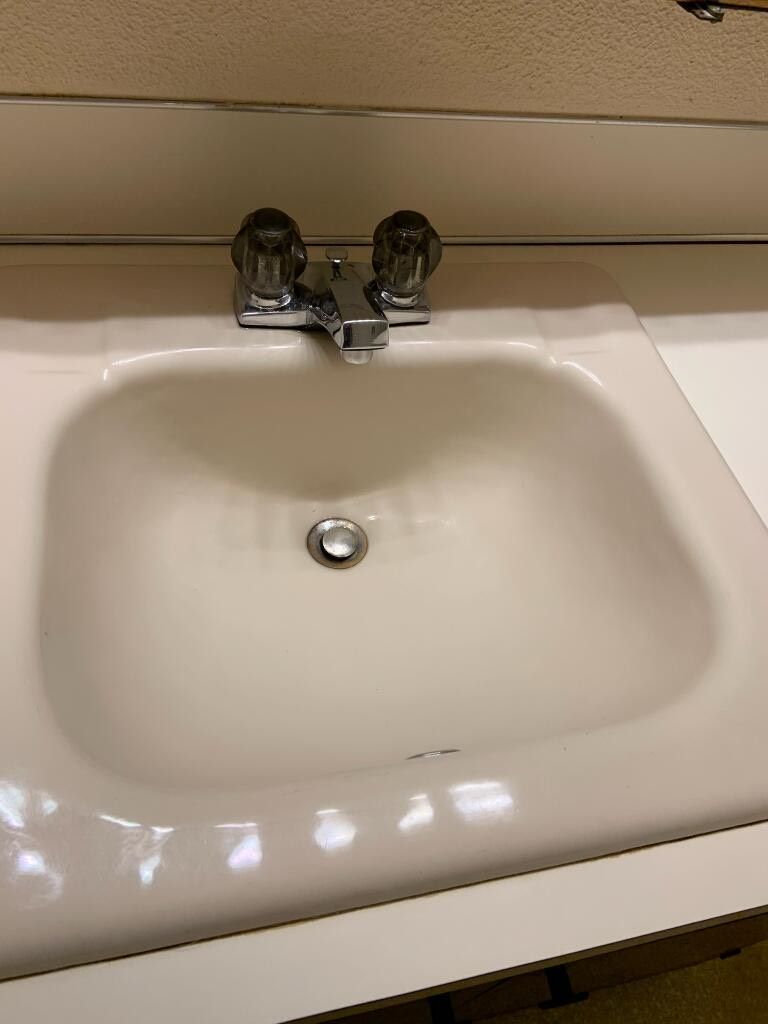 A bathroom sink with a faucet and a sink drain.