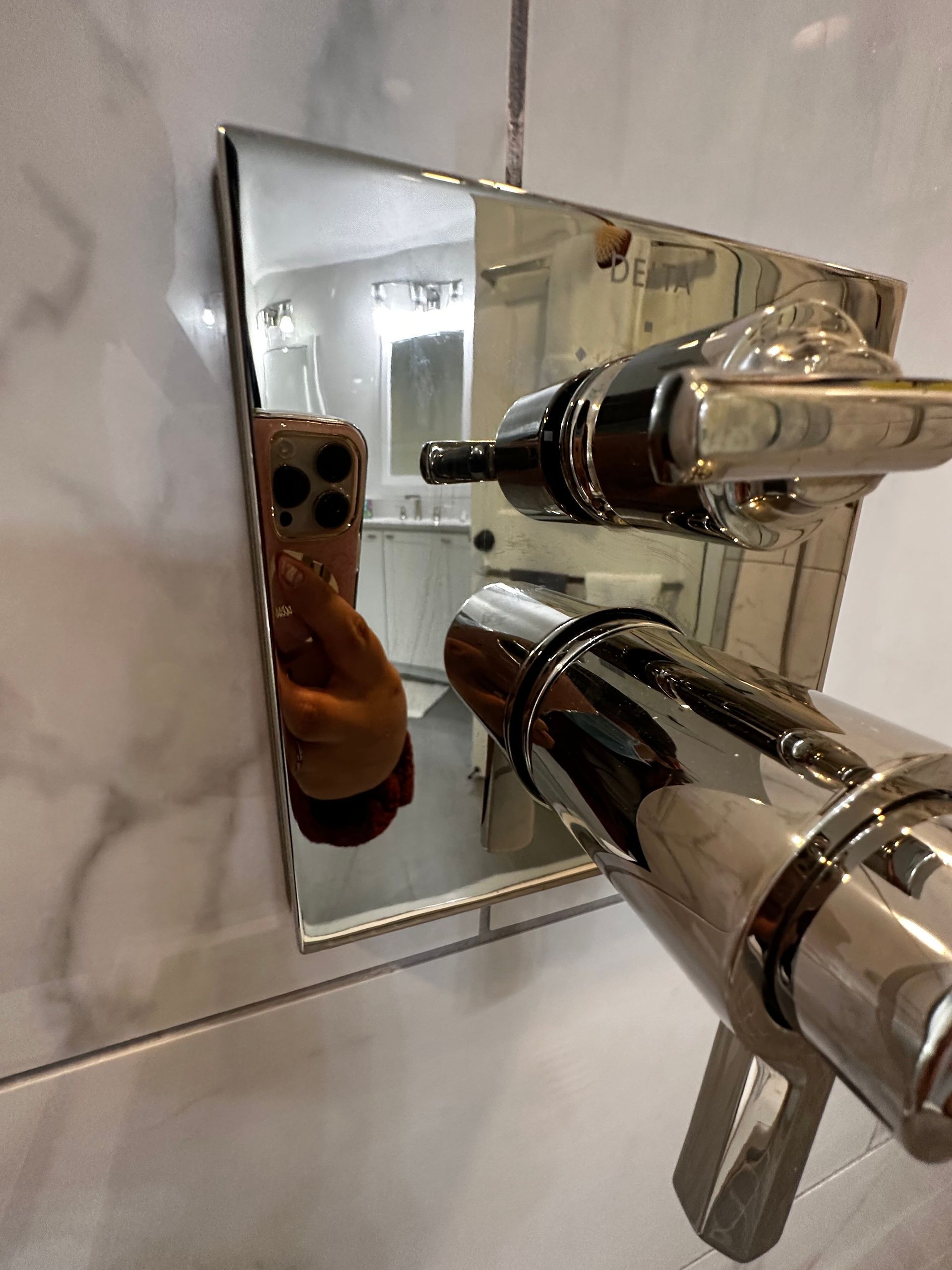 A person is taking a selfie in front of a mirror in a bathroom.