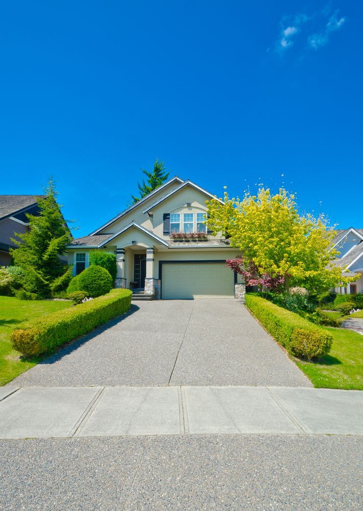 Woman in straw hat smiles, holding wine glass near a lake.