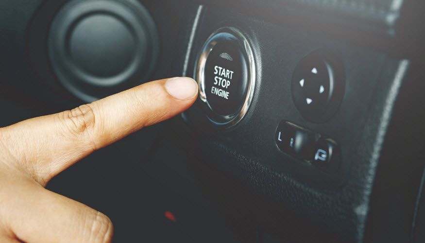 A person is pressing a button on the dashboard of a car. | Import Specialty Service