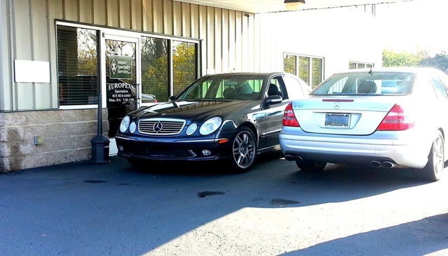 Two cars are parked in front of a building | Import Specialty Service