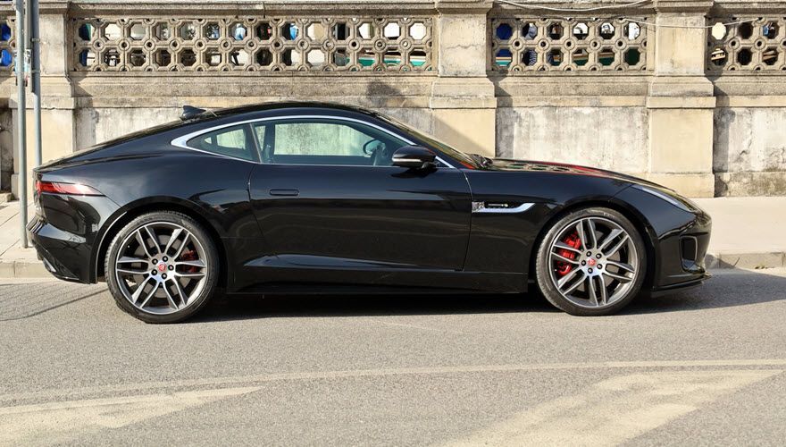 A black sports car is parked on the side of the road. | Import Specialty Service