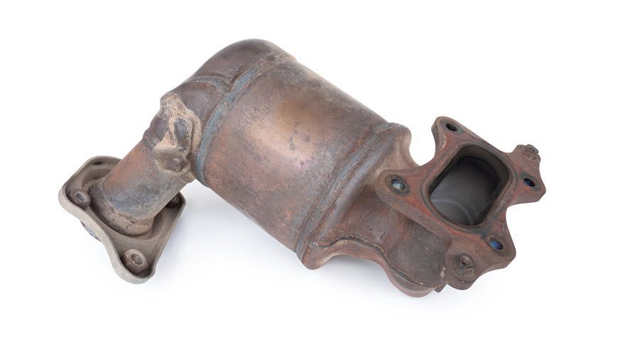A close up of a rusty exhaust pipe on a white background. | Import Specialty Service