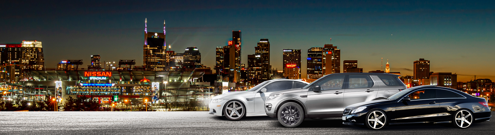 A car is on a lift in a garage next to a building | Import Specialty Service