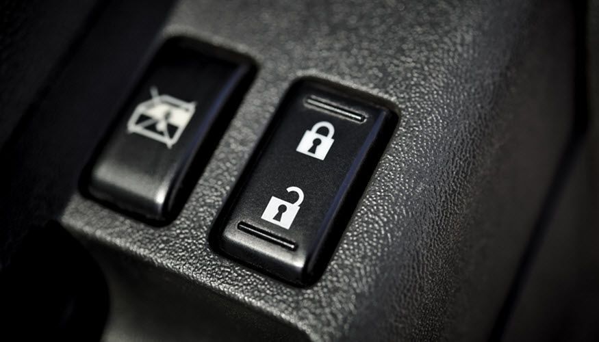 A close up of a car door lock and unlock button. | Import Specialty Service