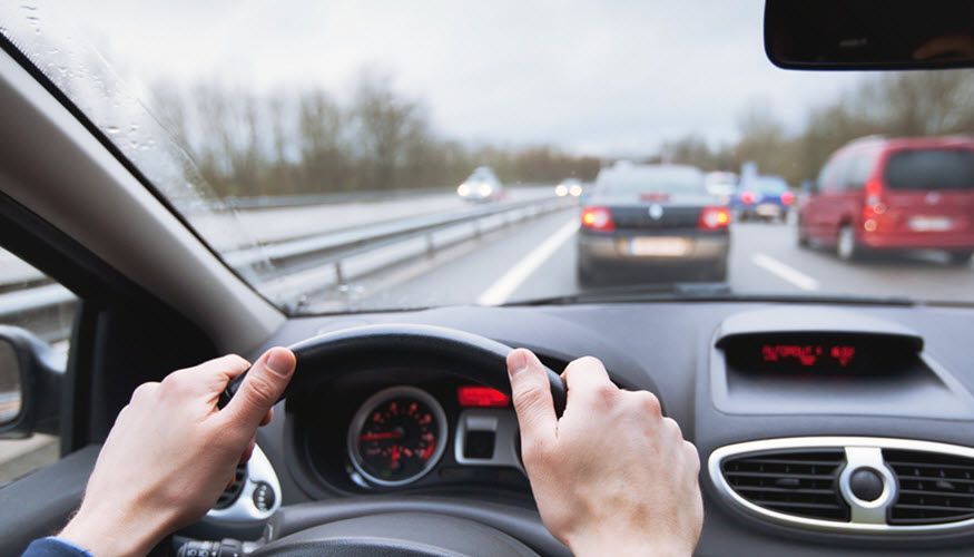 A person is driving a car on a highway. | Import Specialty Service