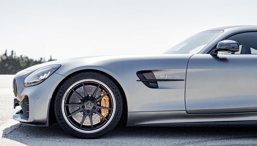 A silver sports car is parked on the side of the road. | Import Specialty Service