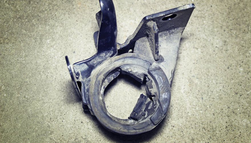 A broken piece of metal is sitting on a concrete surface. | Import Specialty Service