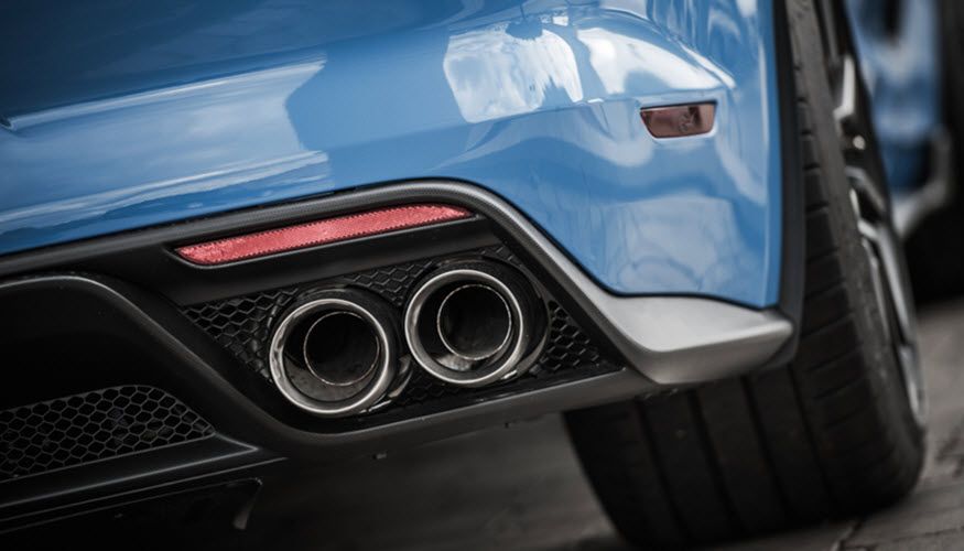 A close up of the exhaust pipes of a blue sports car. | Import Specialty Service