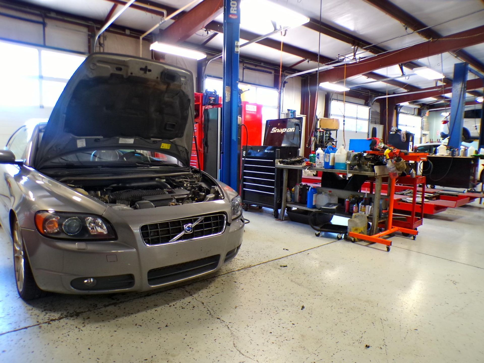 A car with the hood up in a garage | Import Specialty Service