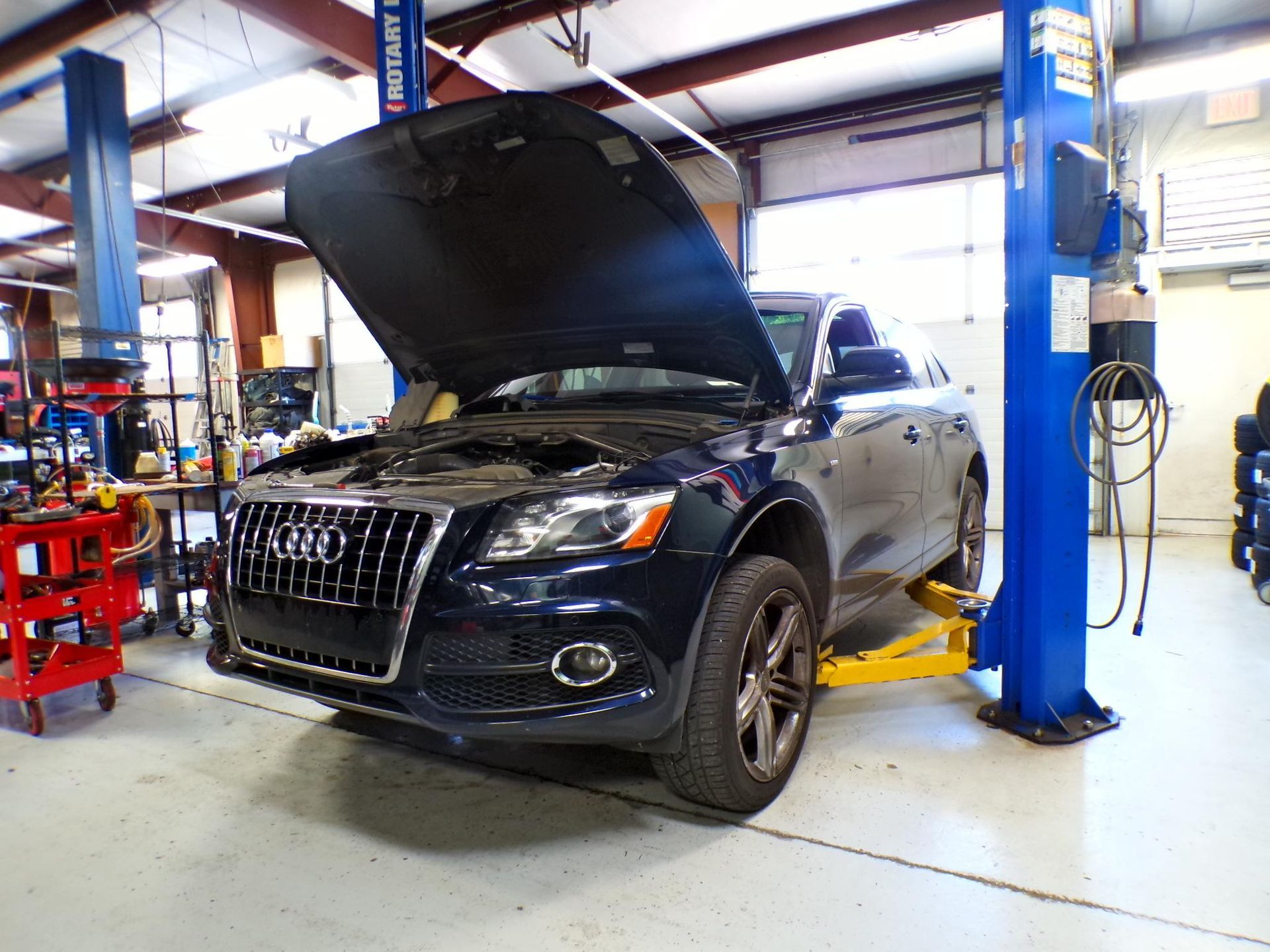A black audi q5 is sitting on a lift in a garage. | Import Specialty Service