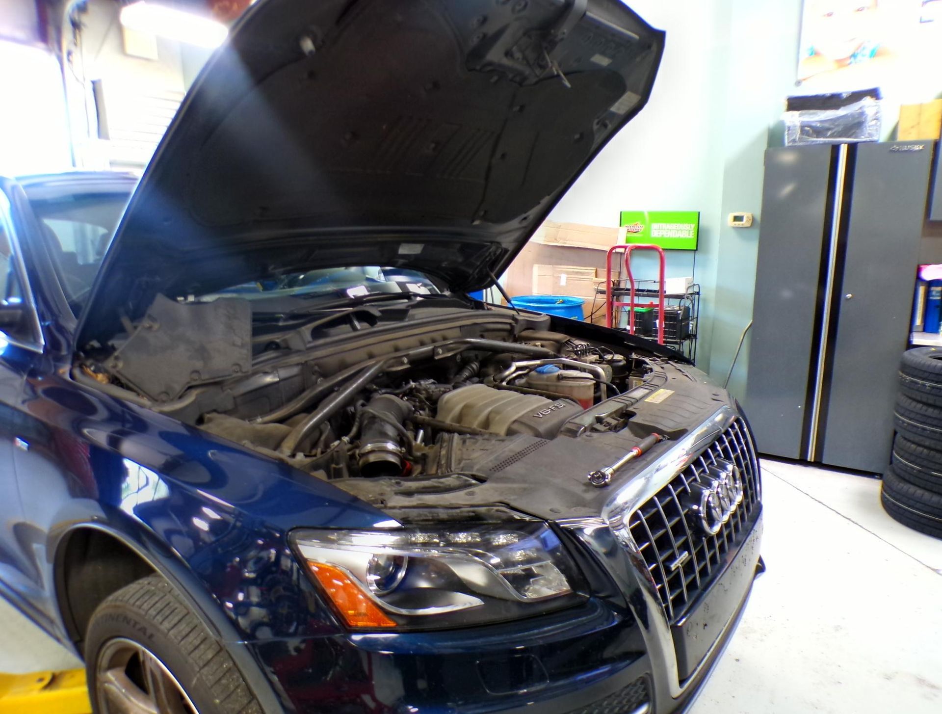 A blue audi with the hood up in a garage | Import Specialty Service