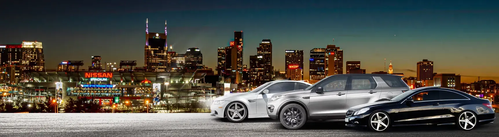 Three vehicles parked outside our the city in the night in Nashville, TN | Import Specialty Service