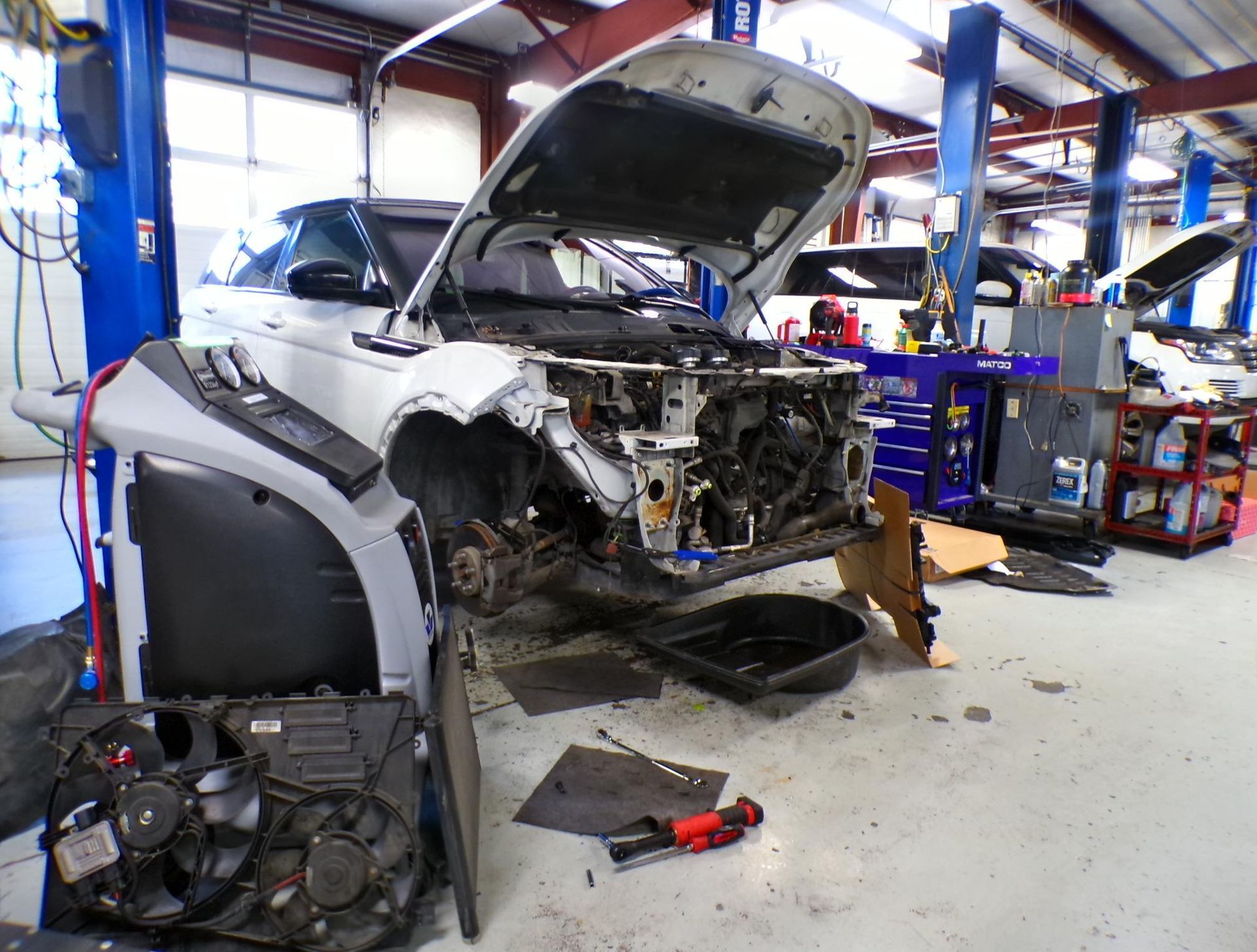 A car is being worked on in a garage with the hood open | Import Specialty Service