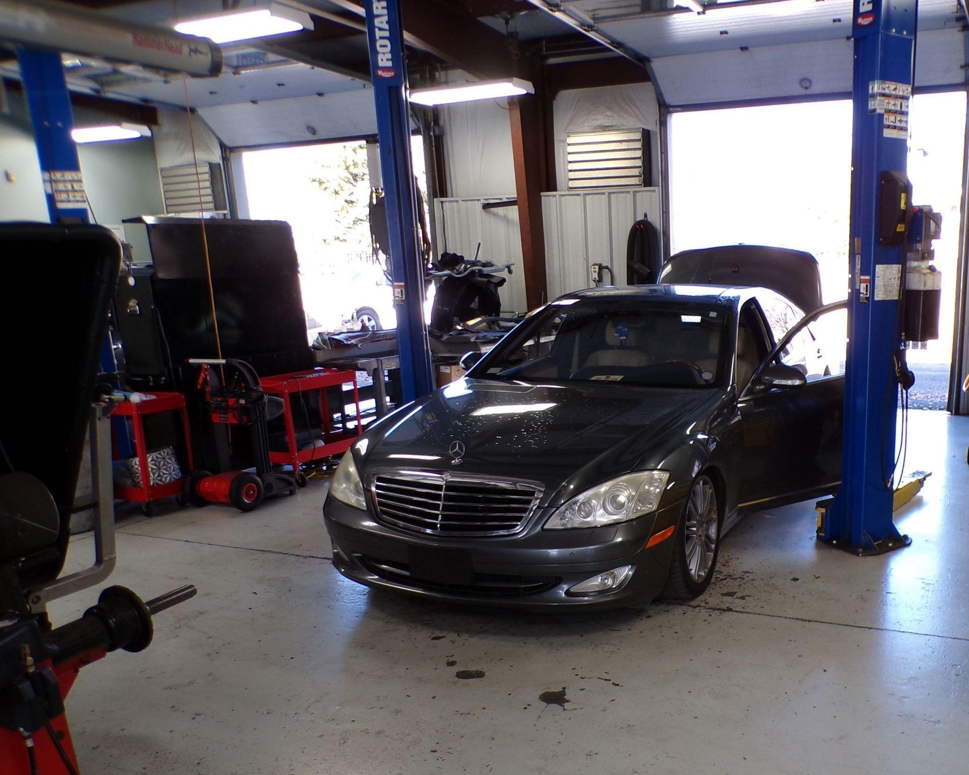 A car is sitting on a lift in a garage | Import Specialty Service
