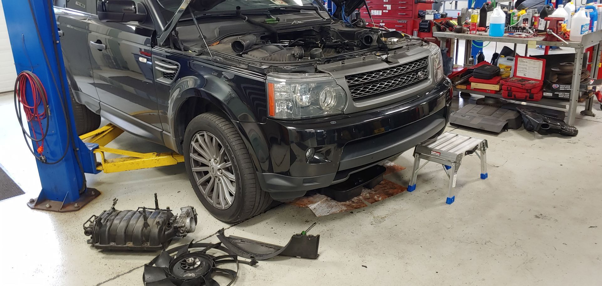 A black range rover is being repaired in a garage. | Import Specialty Service