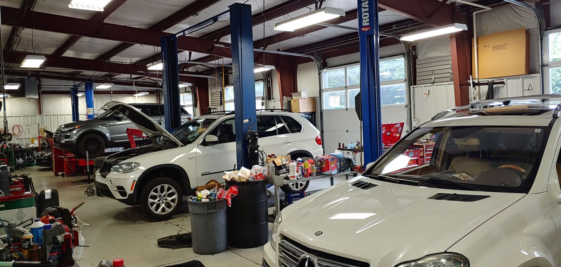 A mercedes benz is sitting on a lift in a garage. | Import Specialty Service