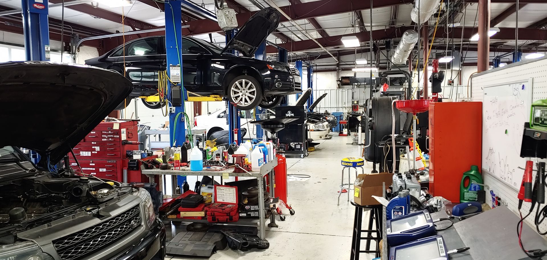 A car is sitting on a lift in a garage. | Import Specialty Service