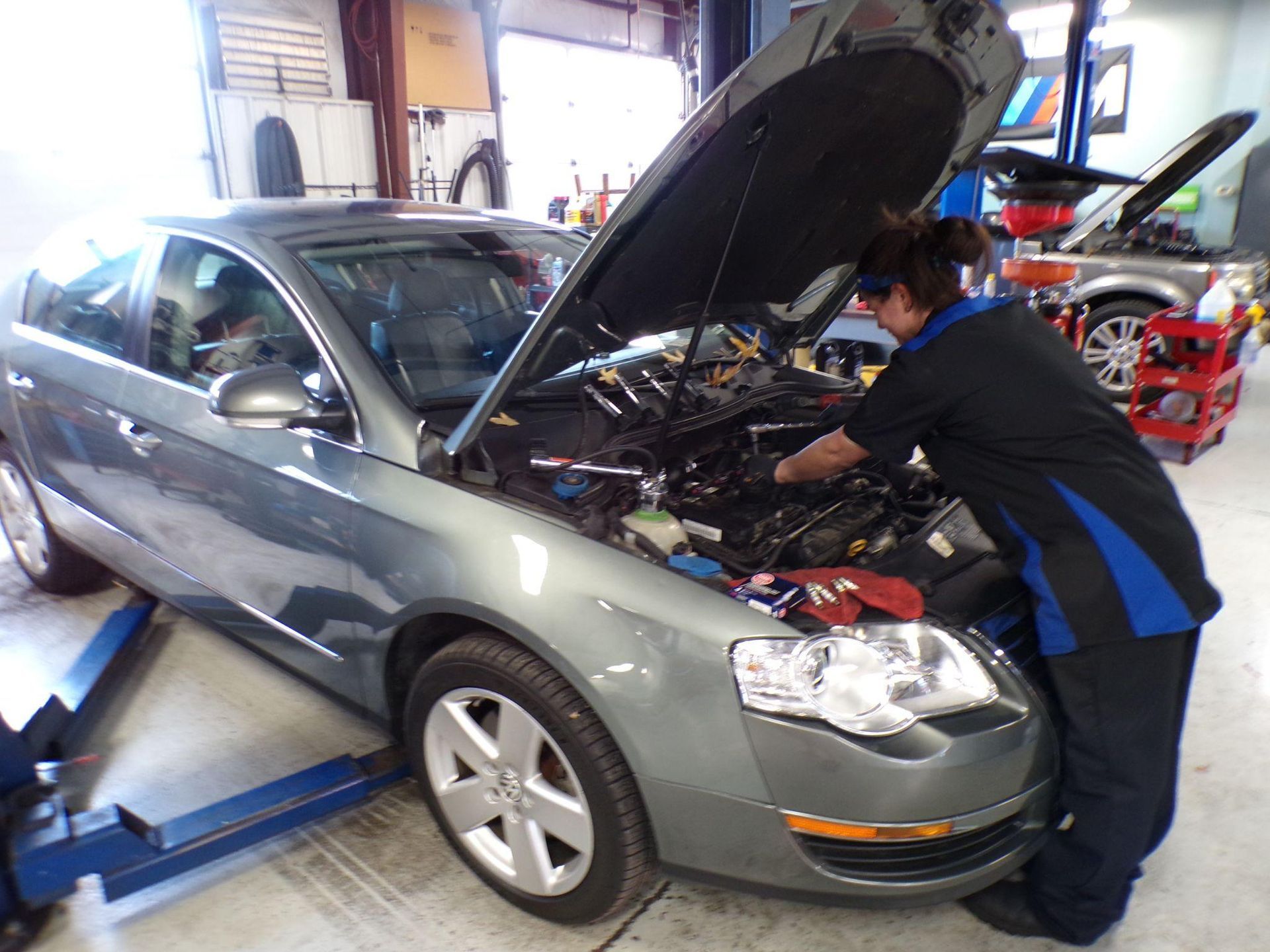 A man is working on a car with the hood open | Import Specialty Service