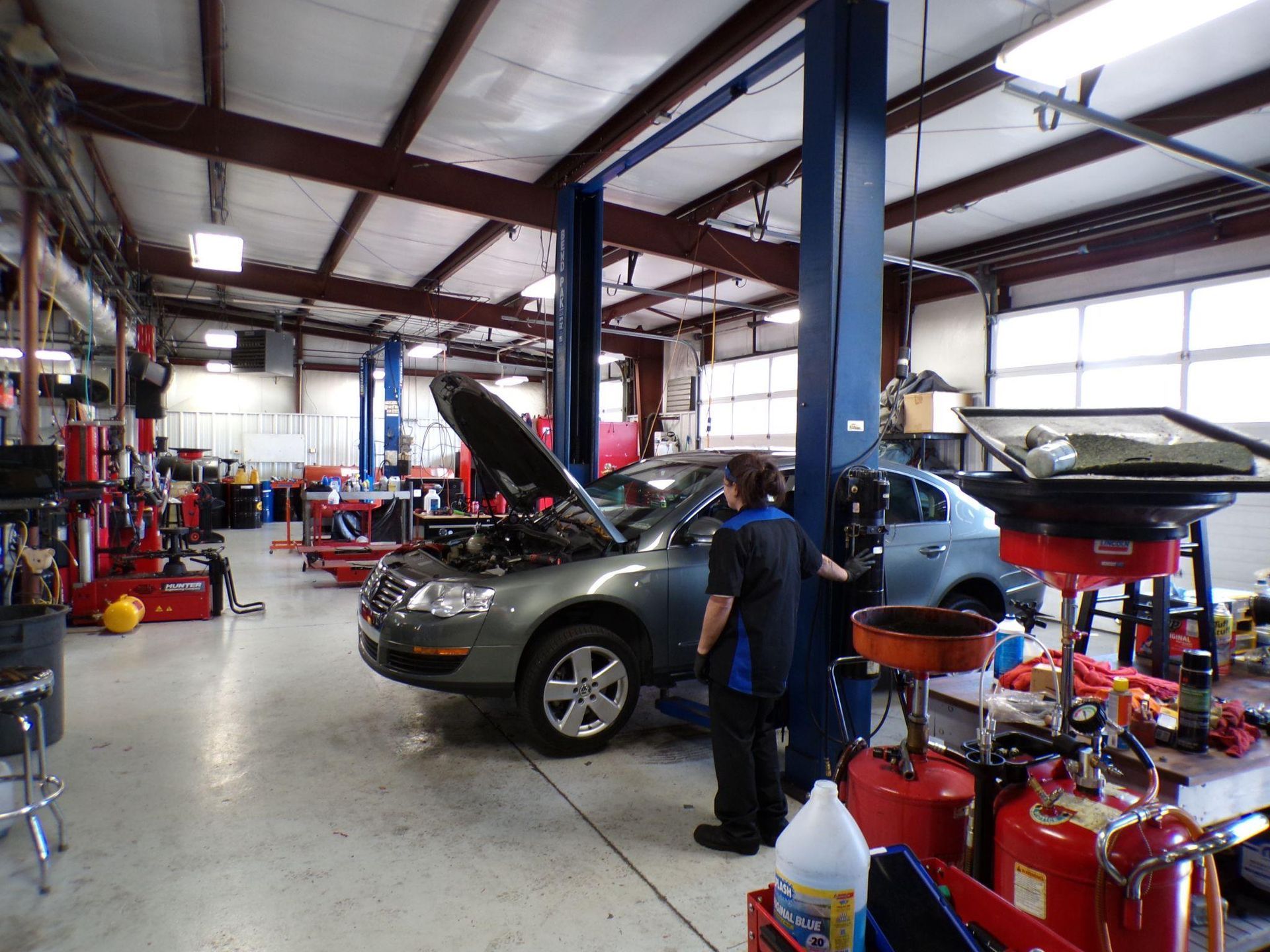 A man is working on a car in a garage. | Import Specialty Service