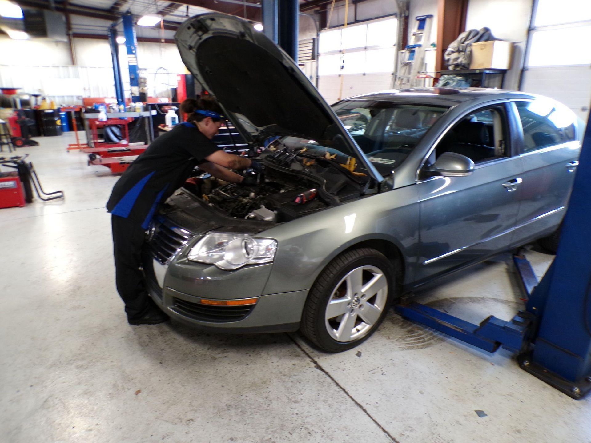 A man is working on a car with the hood open | Import Specialty Service