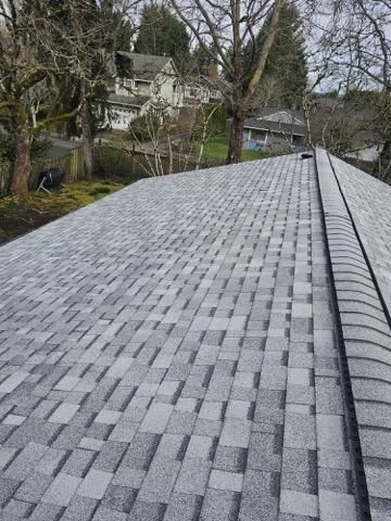 A white house with a tiled roof and balconies against a blue sky with clouds.