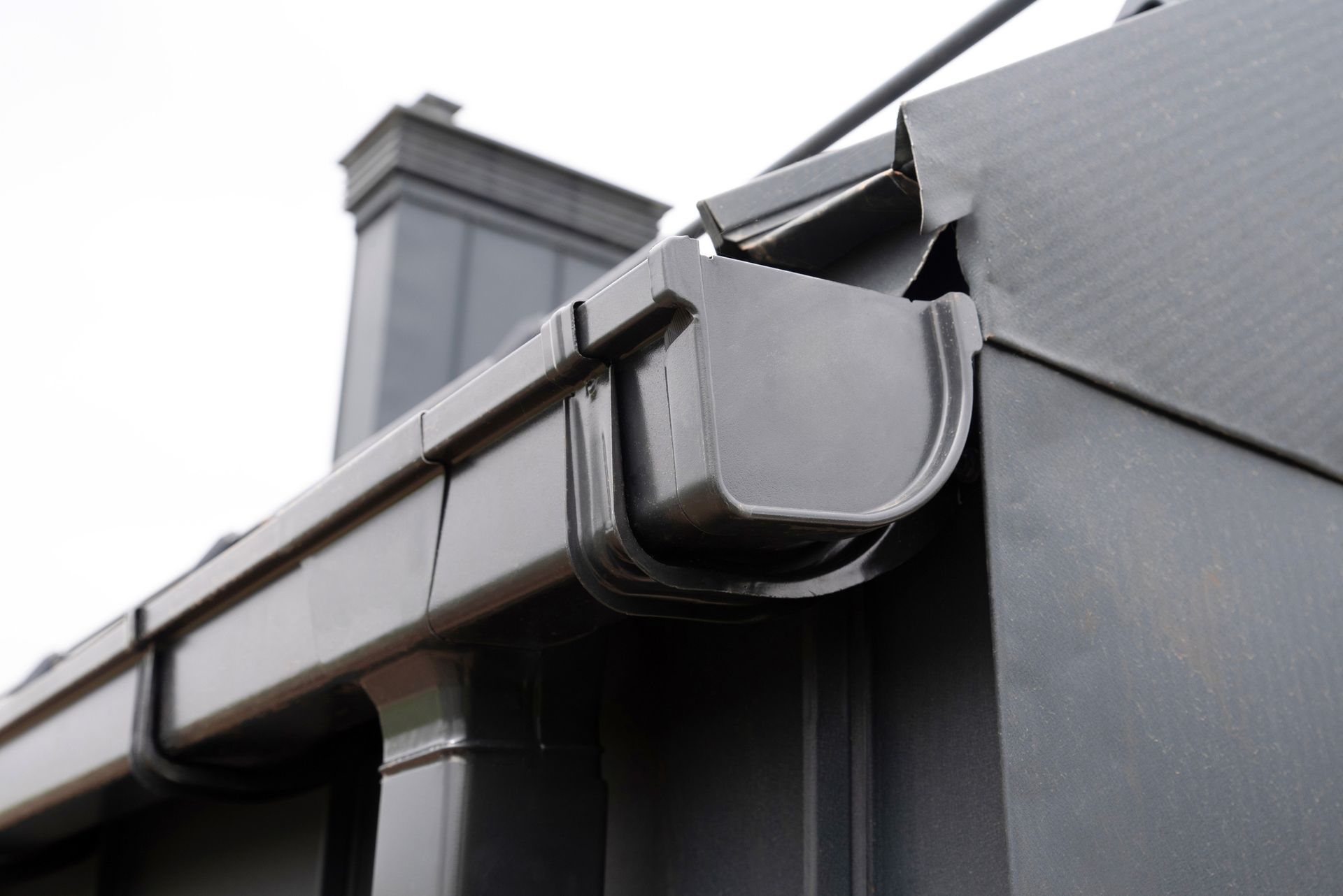 A black gutter on the side of a building