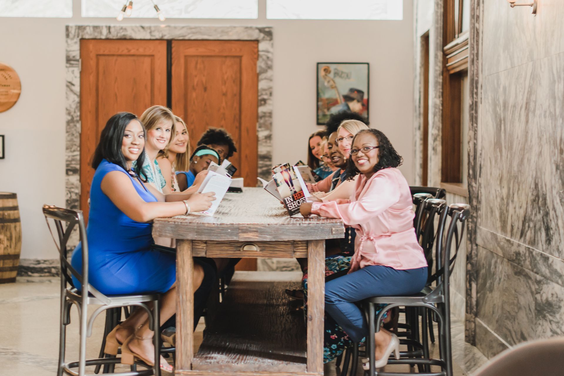 A group of women are sitting at a table with laptops.