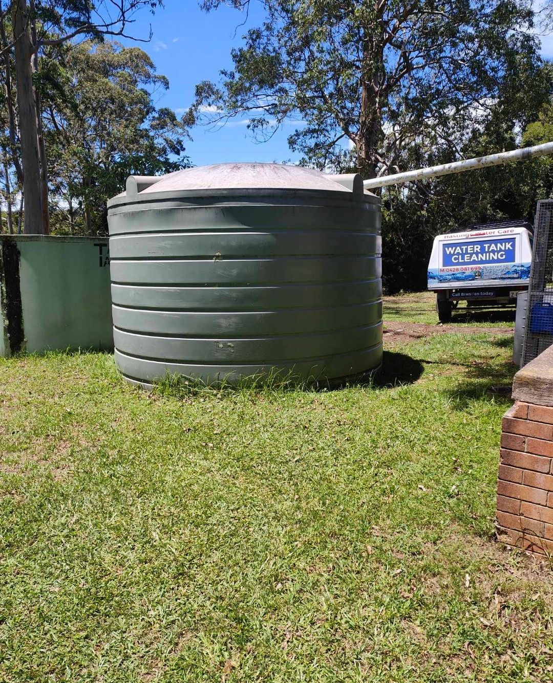 Green water tank with a branded work vehicle parked next to it - Hastings Water Care in Port Macquarie NSW