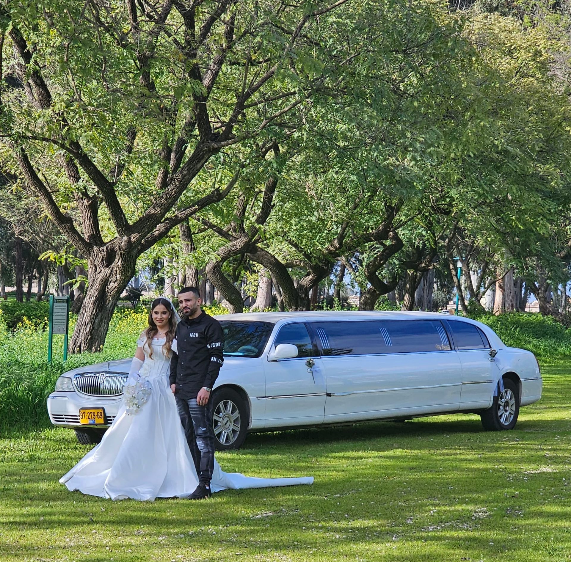 חתן וכלה ביום צילומים עם לימוזינה