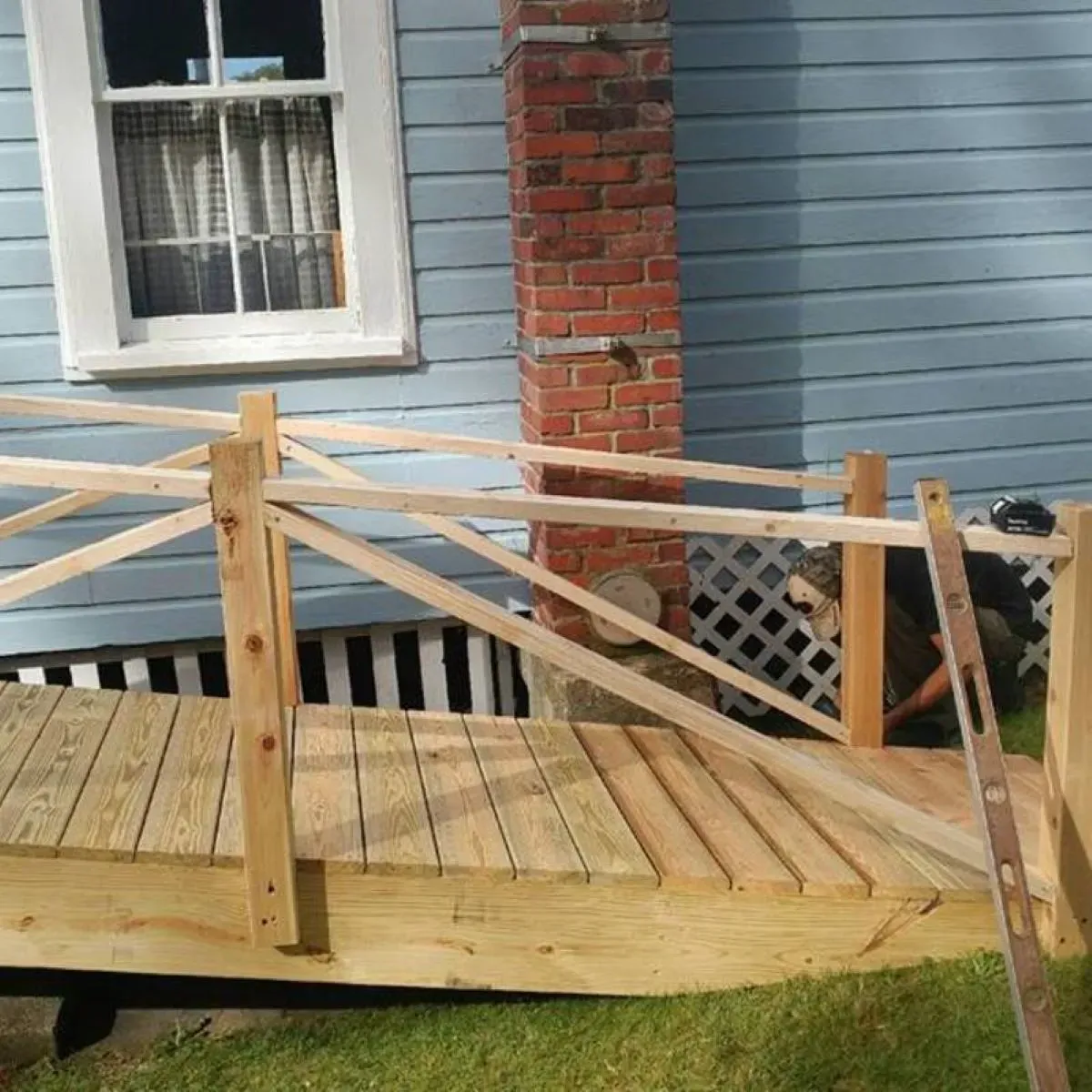 A wooden bridge is being built in front of a house