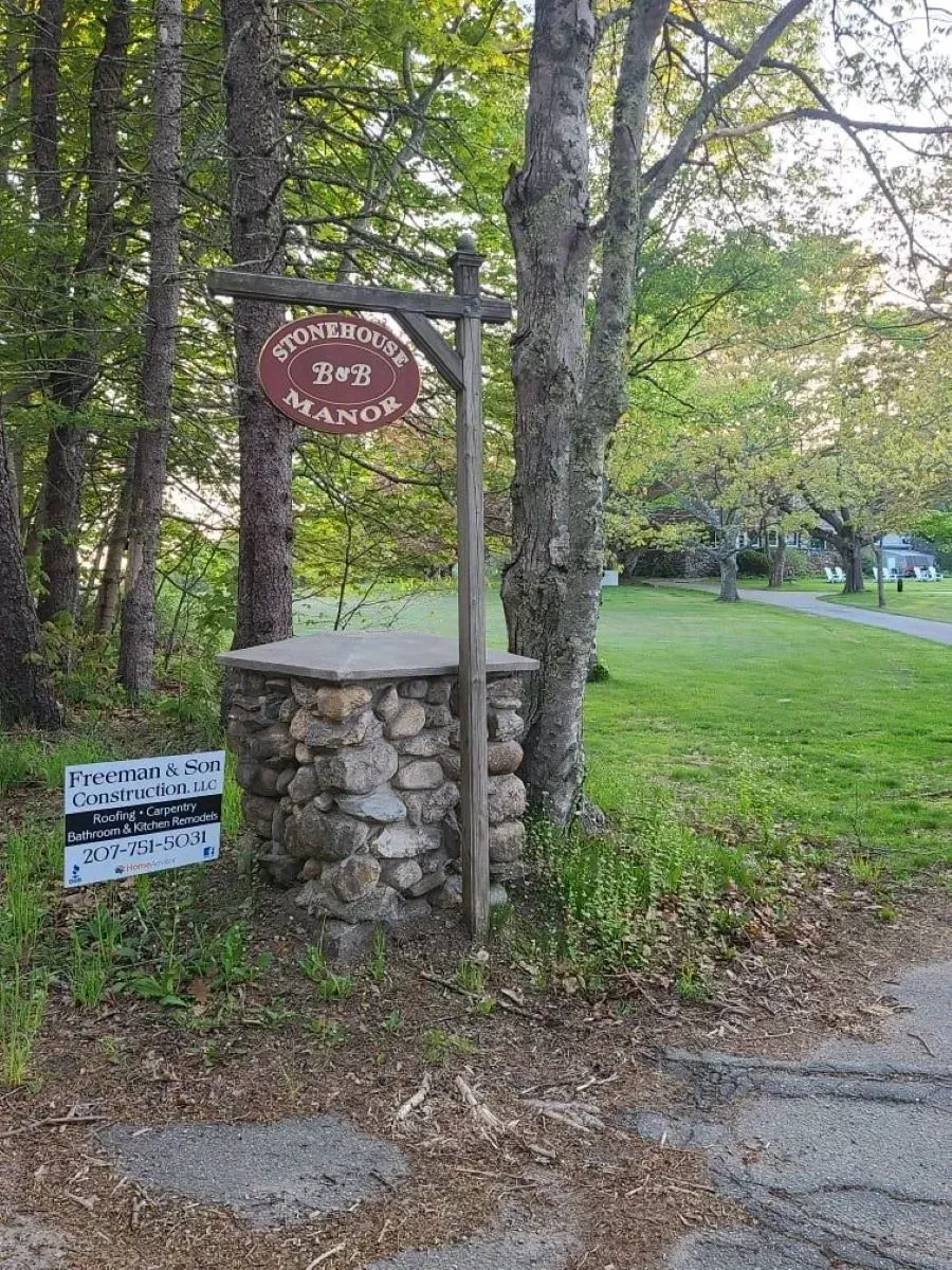 A sign on a pole in the middle of a forest.