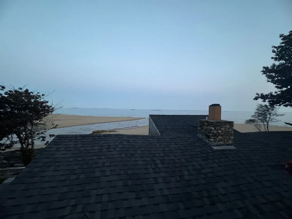 A view of the ocean from the roof of a house.
