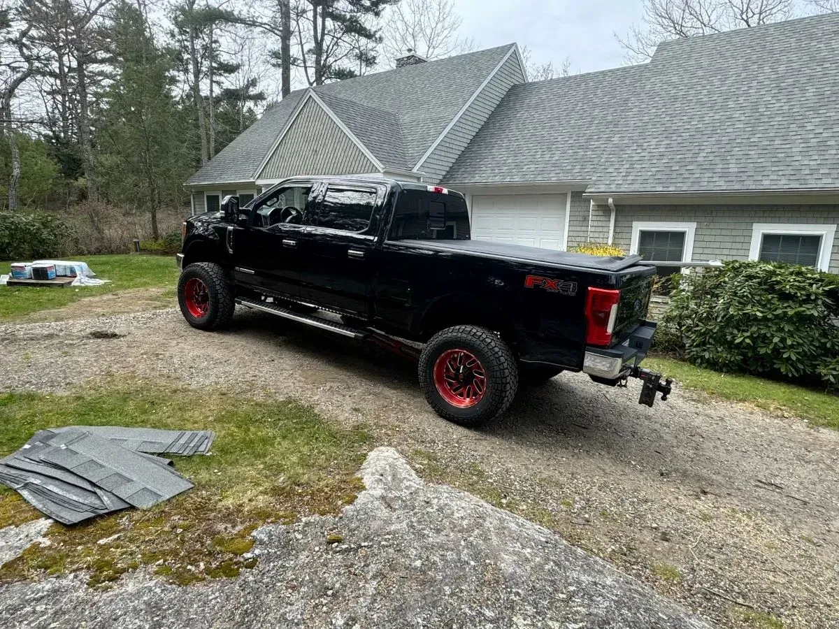 A black truck is parked in front of a house.