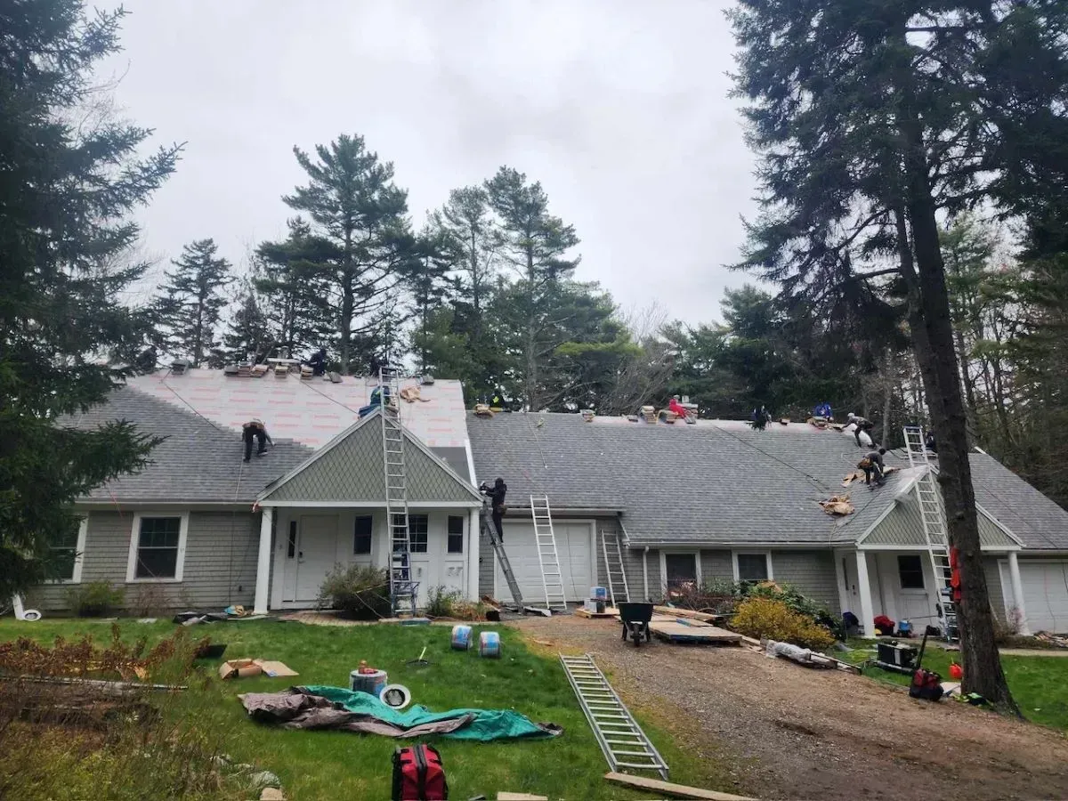 A large house is being remodeled with a roof being installed.