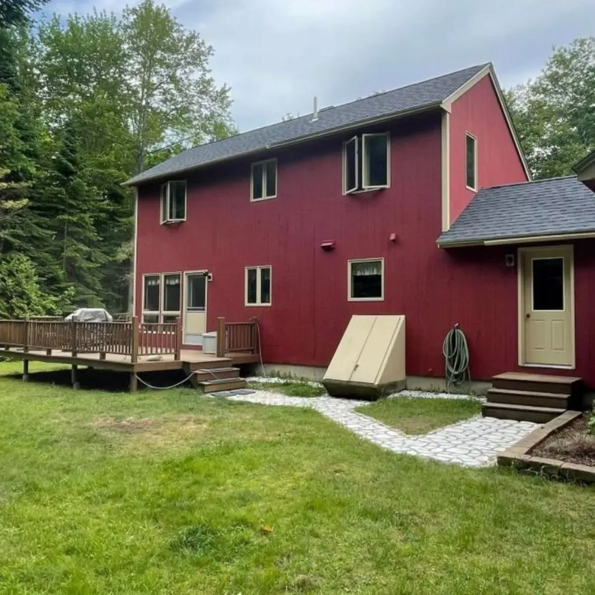 A large red house with a deck in front of it