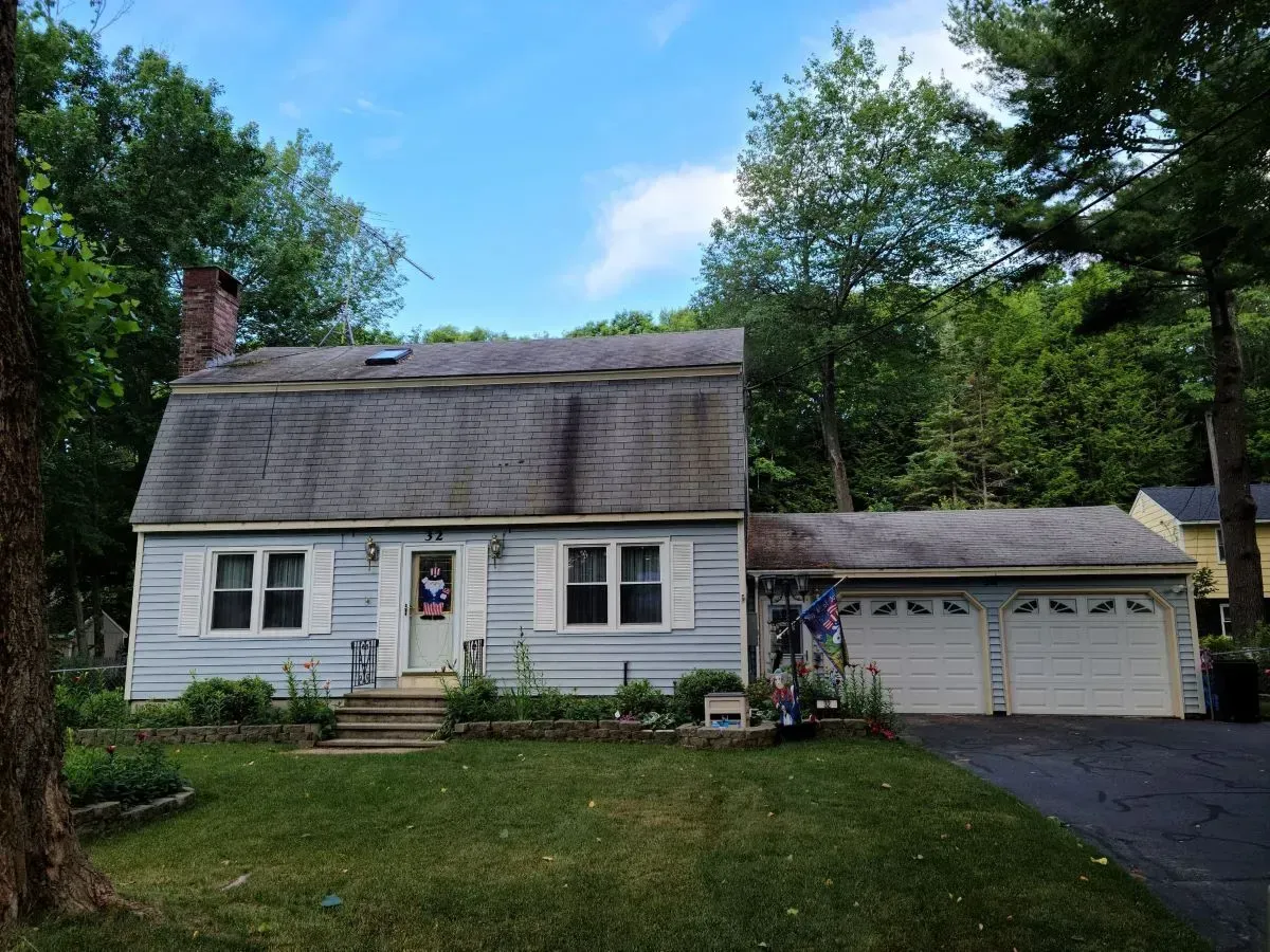 A house with a gray roof and white garage doors