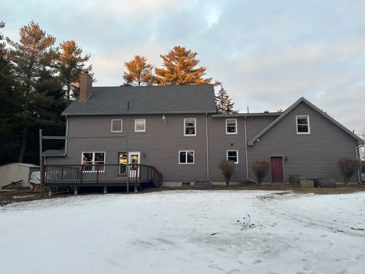 A large house with a large deck and a lot of windows