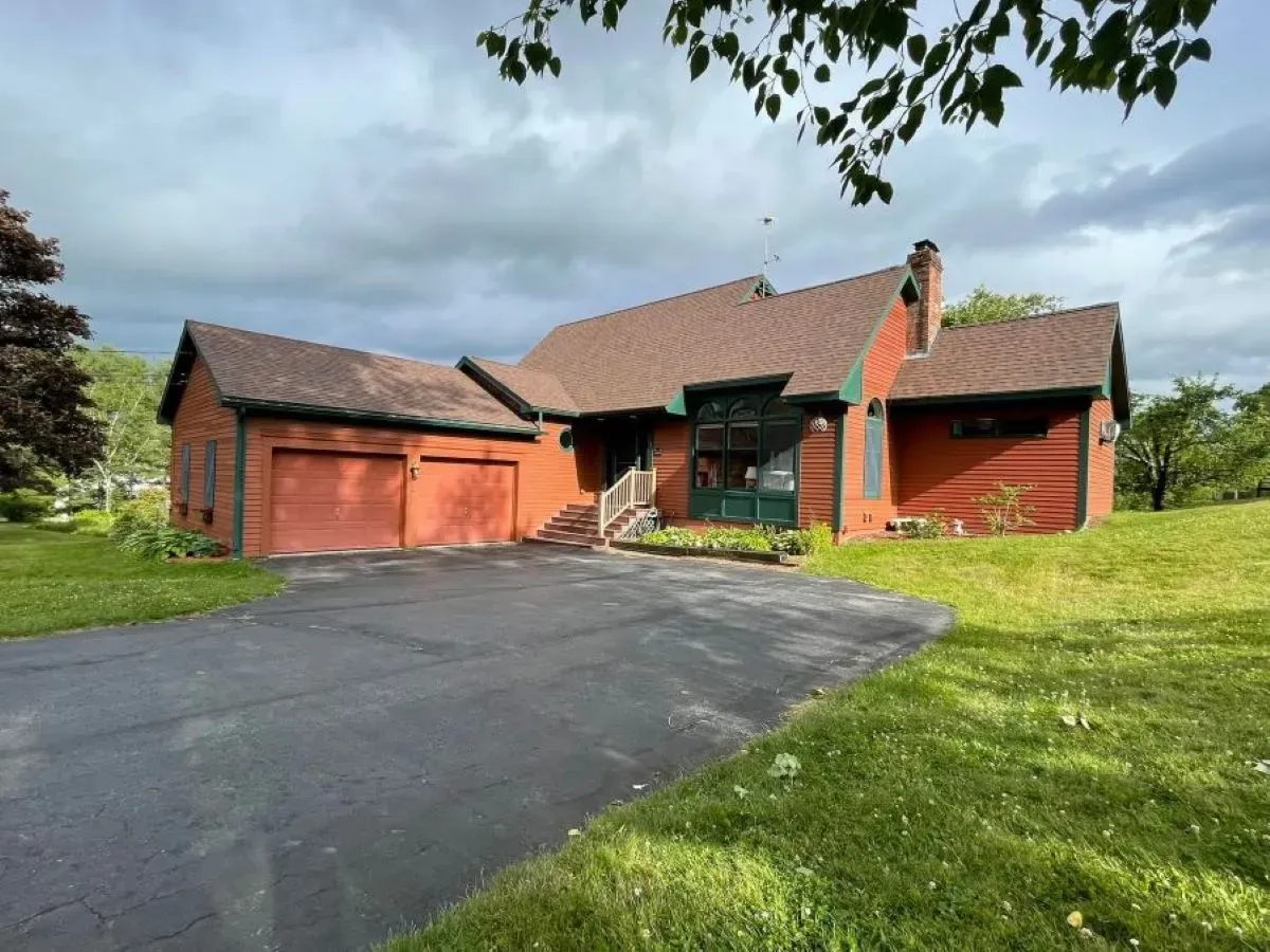 A large red house with two garages and a driveway