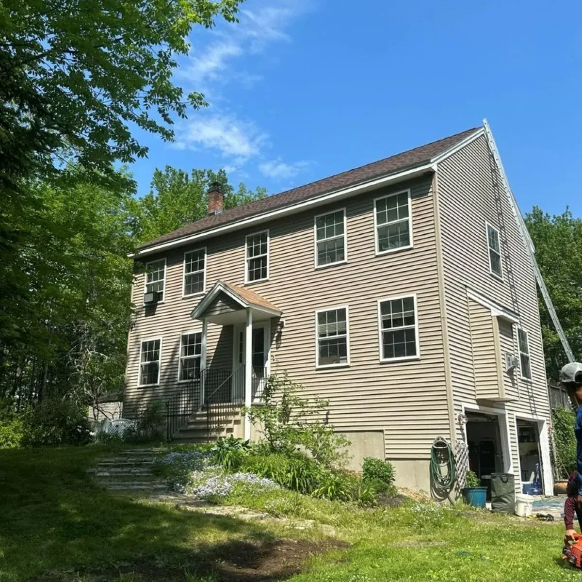 A house with a lot of windows is surrounded by trees