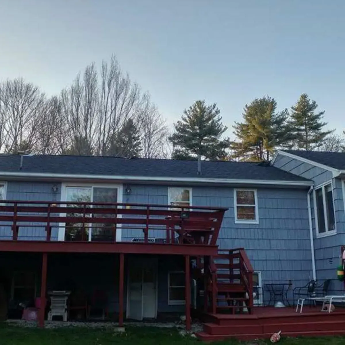 A blue house with a red deck and stairs