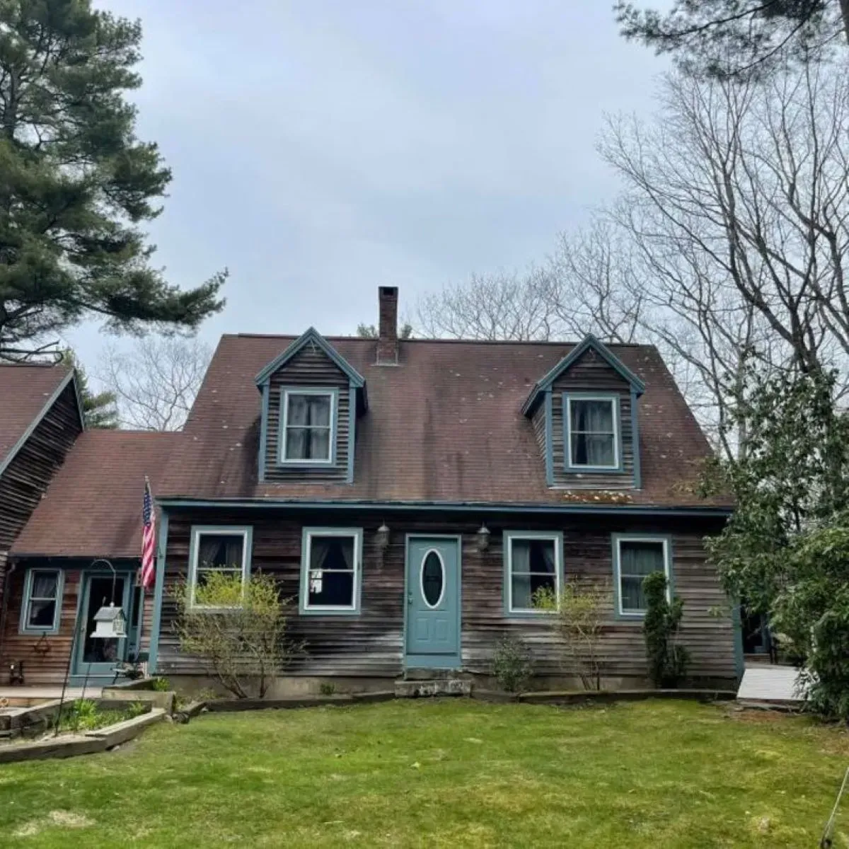 A log cabin with a brown roof and a blue door
