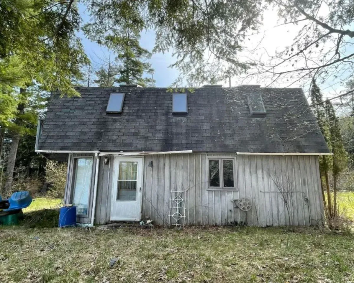 A small house with a roof that has two skylights on it.