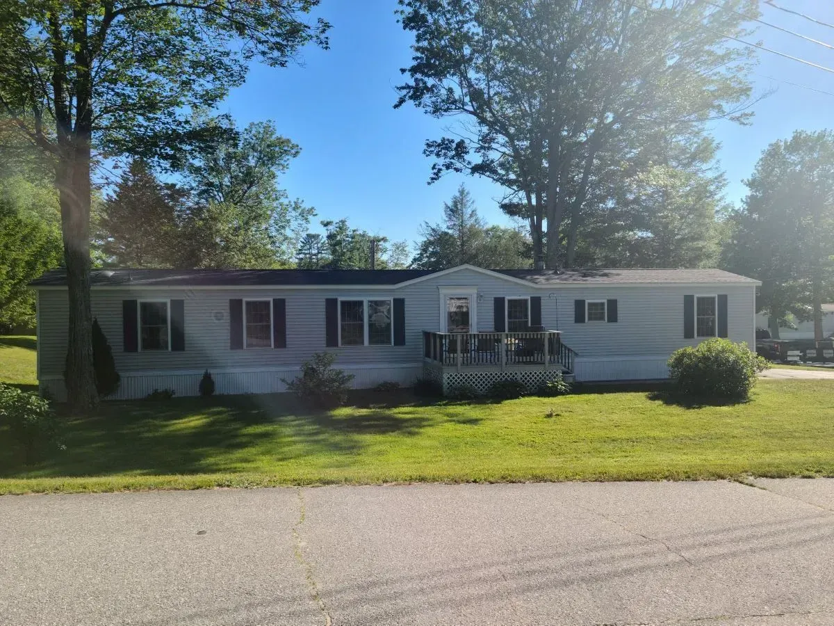A mobile home with a lot of windows and a porch