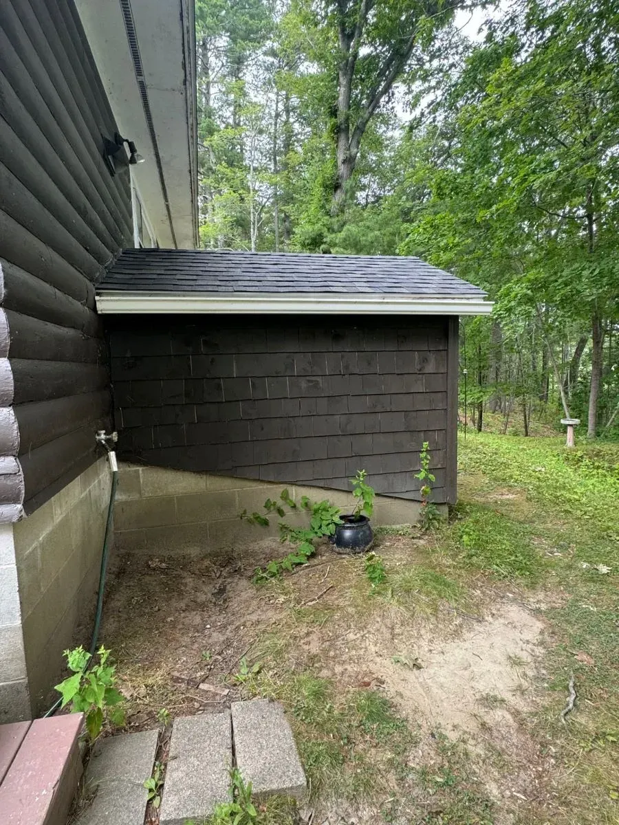 There is a shed in the backyard of a house.