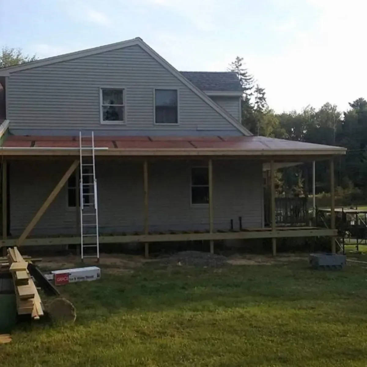 A house with a porch and a ladder in front of it