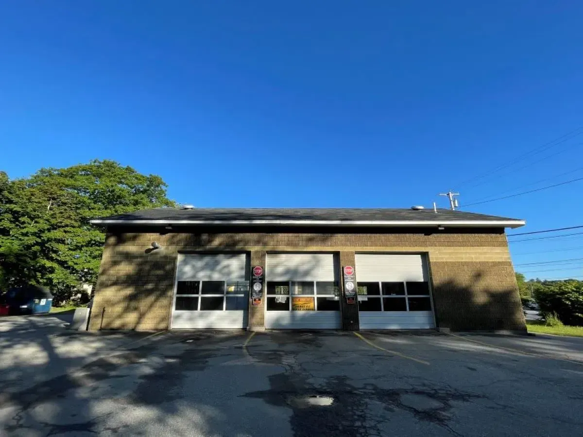 A building with two garage doors and a blue sky in the background