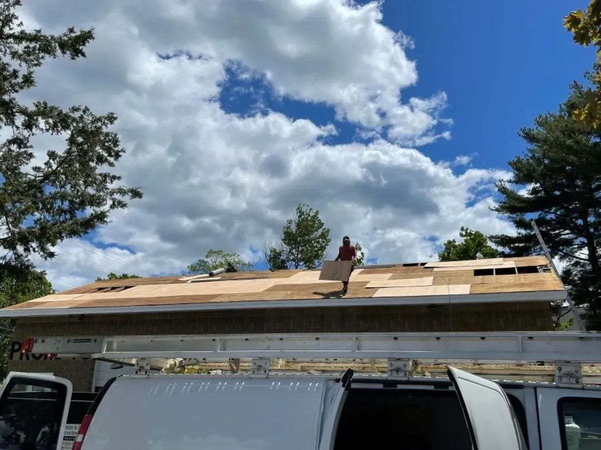 A man is working on the roof of a house.